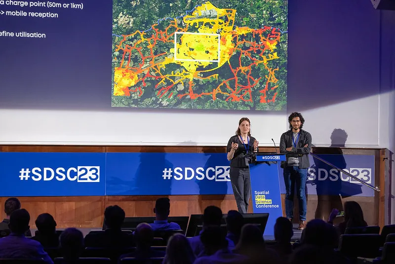 Data science professional on stage showing a map.